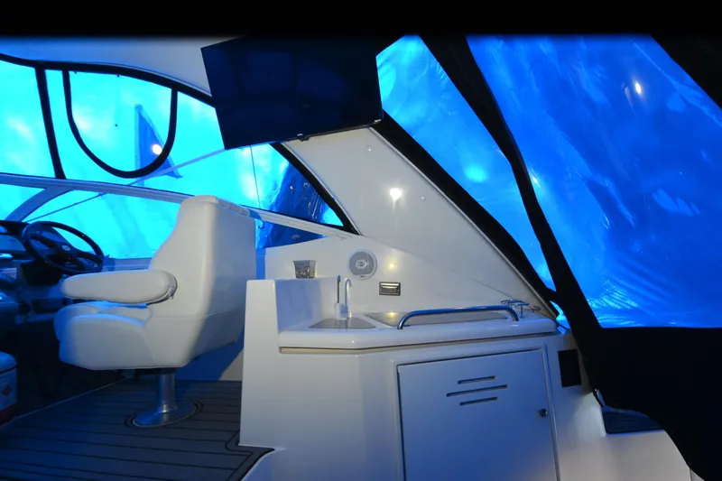Seeking Sara Yacht Photos Pics Interior of 2003 Cruisers Yachts 4370 Express with blue-tinted windows and helm station.