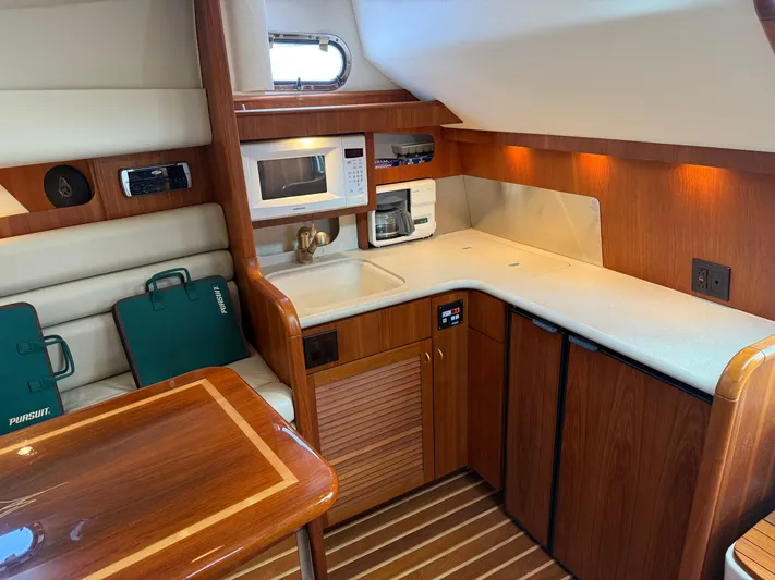 Cyette Yacht Photos Pics Luxurious 2003 Pursuit 3800 Express yacht interior with kitchenette and seating area.