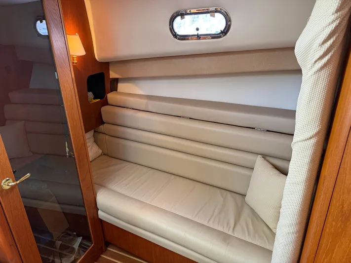 Cyette Yacht Photos Pics 2003 Pursuit 3800 Express cabin interior with beige leather seating and wooden accents.