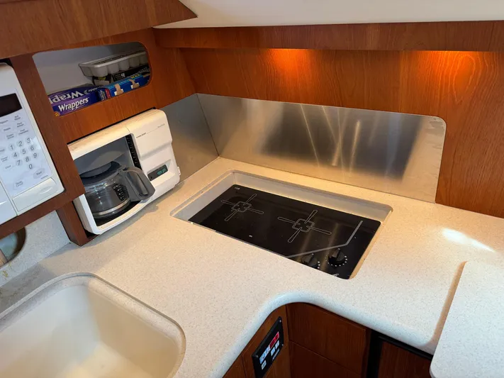 Cyette Yacht Photos Pics 2003 Pursuit 3800 Express yacht kitchen with stove, microwave, and coffee maker.