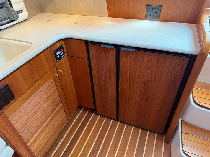 Cyette Yacht Photos Pics 2003 Pursuit 3800 Express yacht kitchen with wood cabinets and compact appliances.