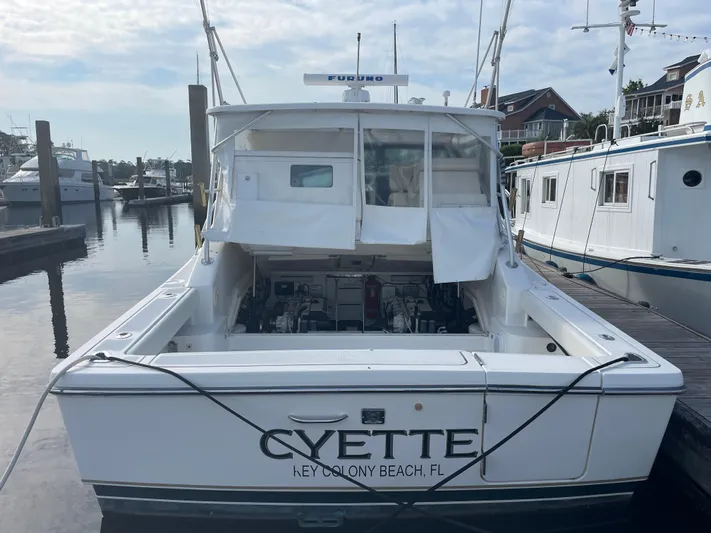 Cyette Yacht Photos Pics 2003 Pursuit 3800 Express boat docked at marina, rear view with open cockpit.