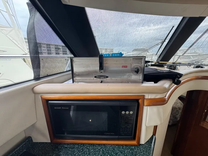  Yacht Photos Pics Interior of 2000 Carver 450 Voyager Pilothouse with microwave and equipment on counter.