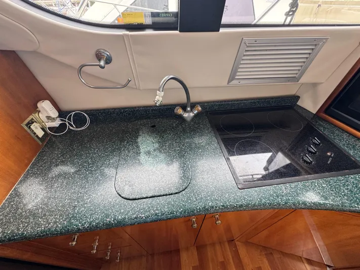  Yacht Photos Pics 2000 Carver 450 Voyager Pilothouse kitchen with green countertop and built-in stove.