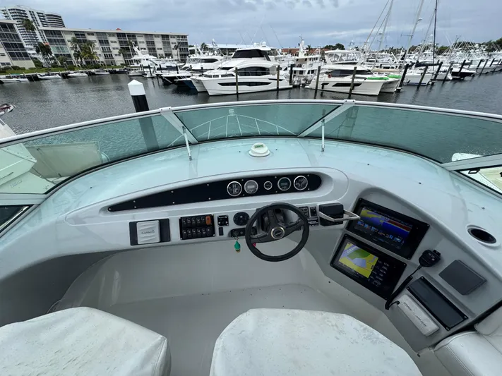  Yacht Photos Pics Pilothouse of 2000 Carver 450 Voyager with marina view, featuring navigation instruments and steering wheel.