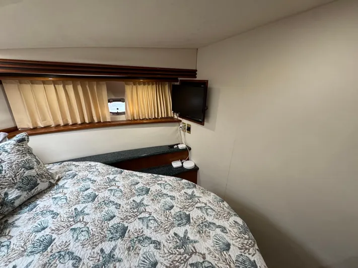  Yacht Photos Pics Bedroom interior of 2000 Carver 450 Voyager Pilothouse with TV and patterned bedding.