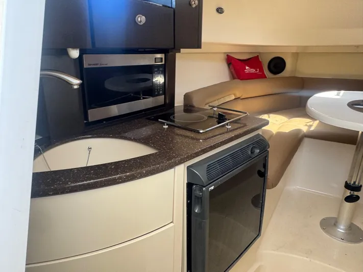  Yacht Photos Pics 2008 Boston Whaler 285 Conquest interior with kitchenette, microwave, and seating area.