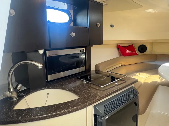  Yacht Photos Pics 2008 Boston Whaler 285 Conquest interior with kitchenette, microwave, and seating area.