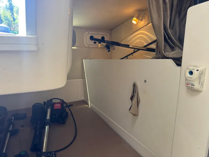  Yacht Photos Pics 2008 Boston Whaler 285 Conquest cabin interior with fishing rods and equipment storage.