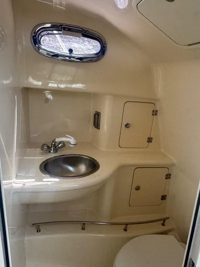  Yacht Photos Pics 2008 Boston Whaler 285 Conquest boat bathroom with sink, toilet, and storage cabinets.
