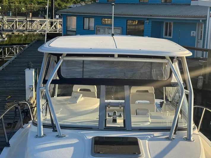  Yacht Photos Pics 2008 Boston Whaler 285 Conquest boat docked at marina with blue building background.