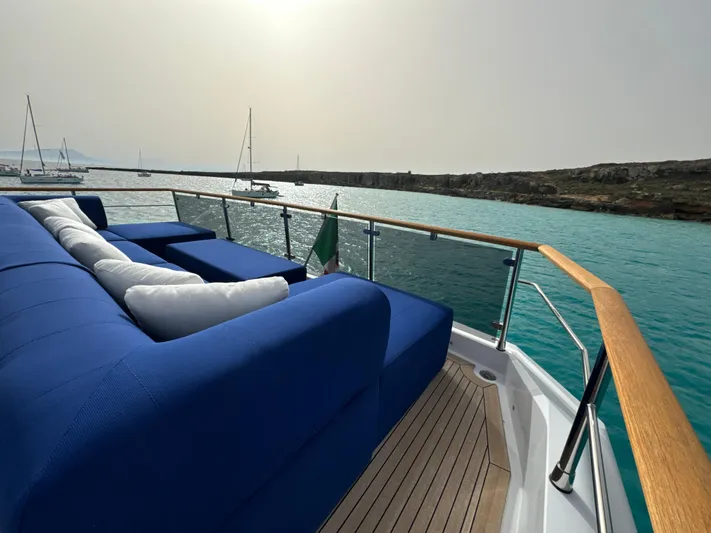 Altvs Yacht Photos Pics Luxurious 2020 PerMare Amer F100 yacht deck with blue seating, overlooking serene waters.