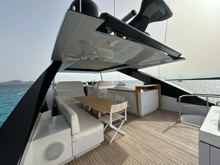Altvs Yacht Photos Pics Luxurious 2020 PerMare Amer F100 yacht deck with seating and dining area, overlooking serene waters.