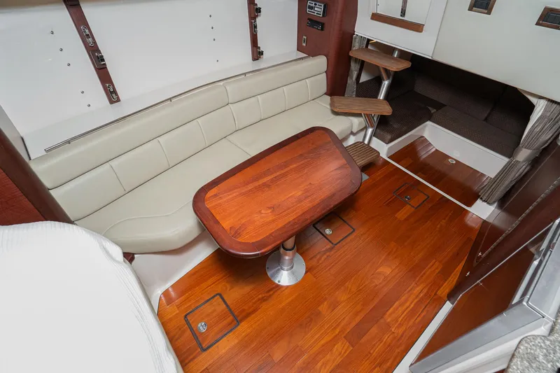 Luna Dei Pescatori Yacht Photos Pics 2009 Boston Whaler 345 Conquest cabin interior with wooden flooring and seating area.