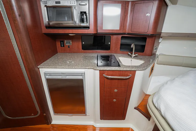 Luna Dei Pescatori Yacht Photos Pics 2009 Boston Whaler 345 Conquest cabin kitchen with microwave, sink, and compact fridge.