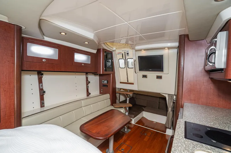 Luna Dei Pescatori Yacht Photos Pics 2009 Boston Whaler 345 Conquest cabin interior with seating, table, and TV.