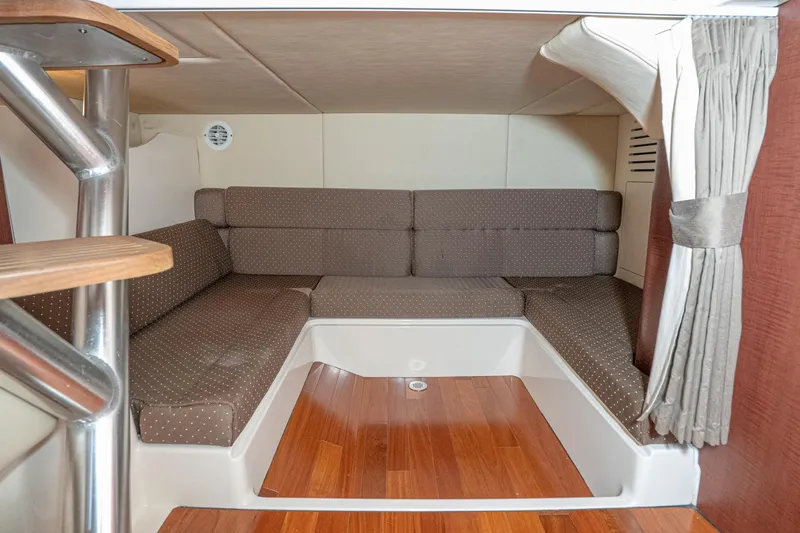 Luna Dei Pescatori Yacht Photos Pics 2009 Boston Whaler 345 Conquest cabin interior with cozy seating and wooden flooring.