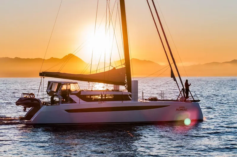  Yacht Photos Pics 2022 HH Catamarans HH55 sailing at sunset with mountains in the background.