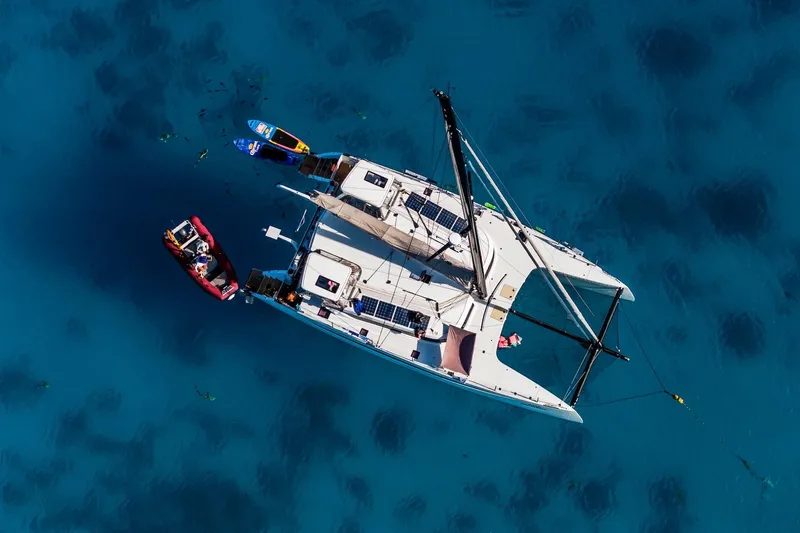  Yacht Photos Pics Aerial view of 2022 HH Catamarans HH55 sailing on clear blue water.