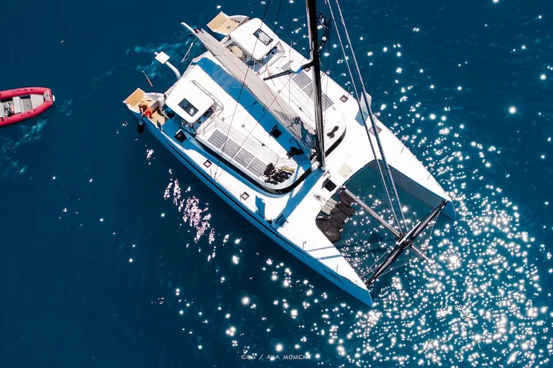  Yacht Photos Pics Aerial view of 2022 HH Catamarans HH55 sailing on sparkling blue water.