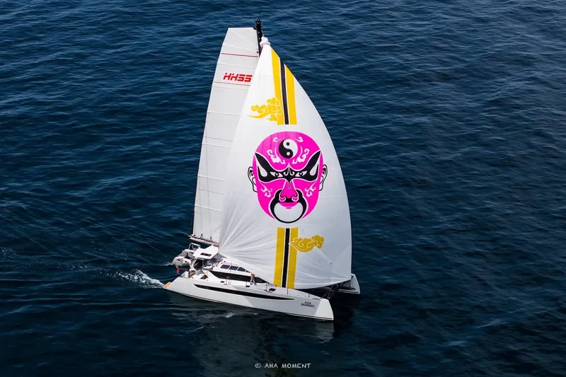  Yacht Photos Pics 2022 HH55 catamaran sailing with vibrant, artistic sail design on open sea.