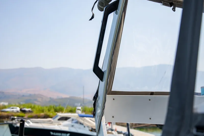 Yacht Photos Pics Close-up of 2022 HH Catamarans HH55 window with scenic mountain backdrop.