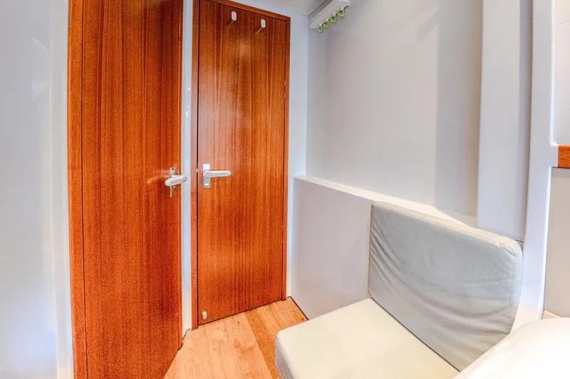  Yacht Photos Pics Interior of 2022 HH Catamarans HH55, featuring wooden doors and a cushioned seat.