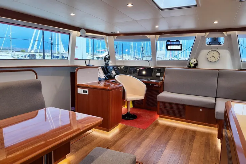  Yacht Photos Pics Luxurious interior of 2022 HH Catamarans HH55, featuring modern navigation station and comfortable seating.