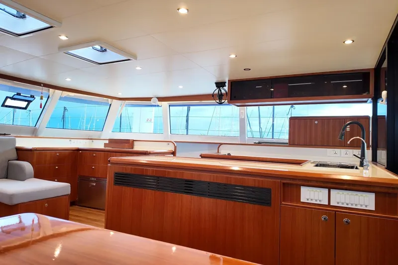  Yacht Photos Pics Luxurious interior of 2022 HH Catamarans HH55 with modern kitchen and panoramic windows.