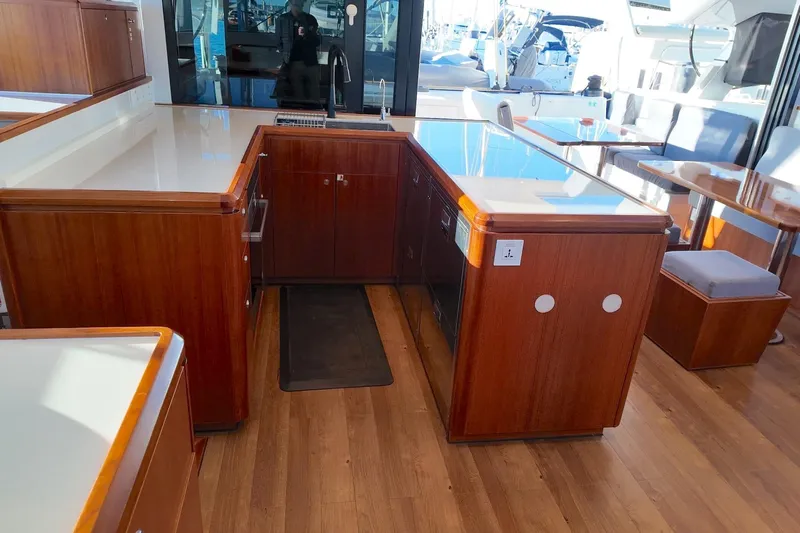  Yacht Photos Pics Luxurious interior of 2022 HH Catamarans HH55, featuring elegant wood cabinetry and modern design.