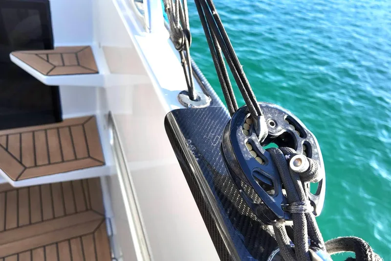  Yacht Photos Pics Close-up of 2022 HH55 Catamaran deck with rigging and turquoise water.