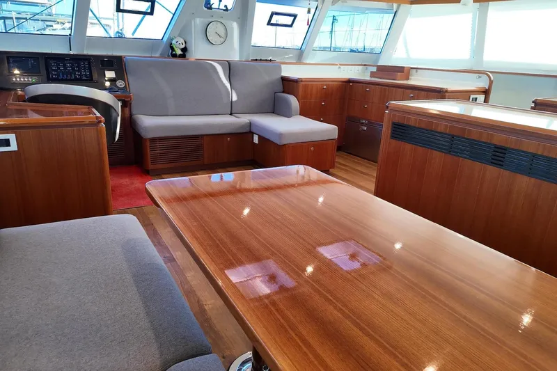  Yacht Photos Pics Luxurious interior of 2022 HH Catamarans HH55 with elegant wood finish and modern seating.