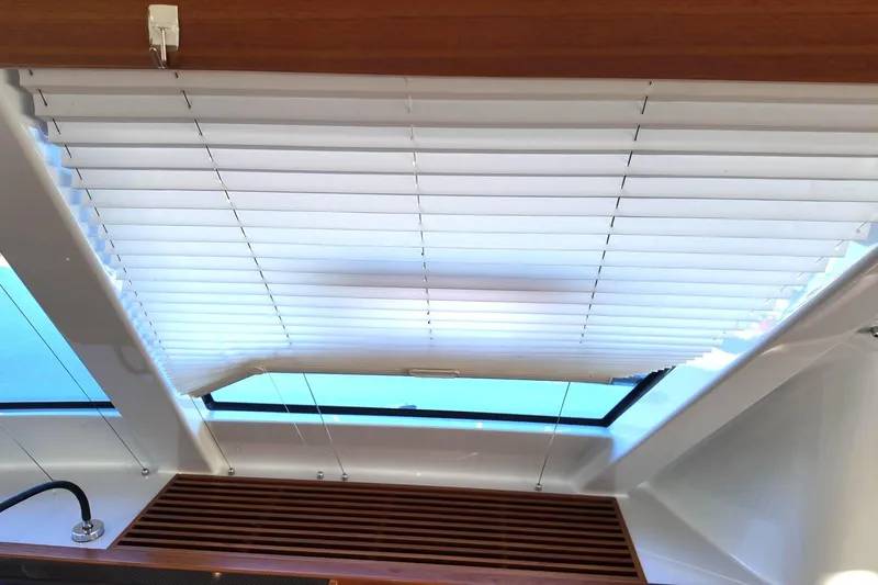  Yacht Photos Pics Interior view of 2022 HH Catamarans HH55 with window blinds and wooden accents.