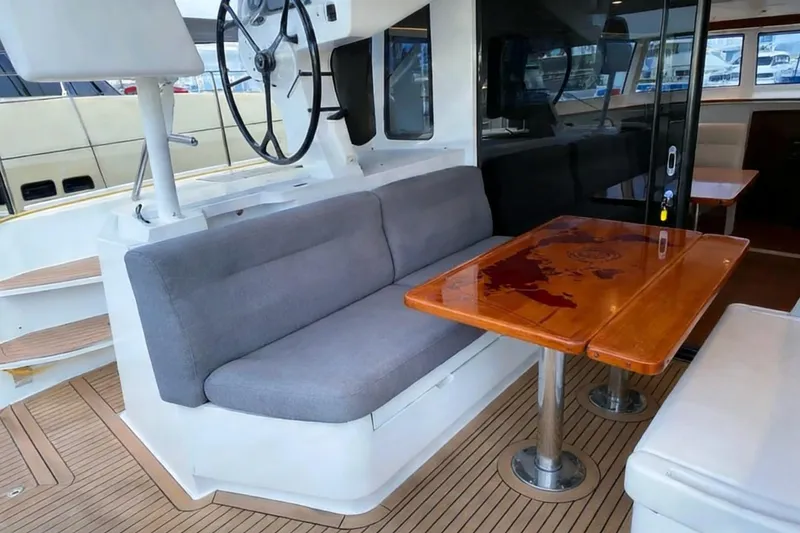  Yacht Photos Pics Luxurious 2022 HH Catamarans HH55 interior with elegant seating and wooden table.