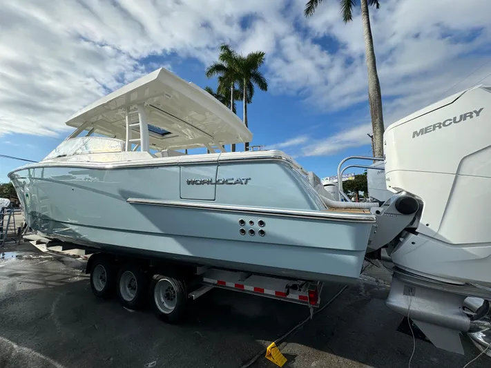 Pcm 51799 400dcis Yacht Photos Pics 2025 World Cat 400 DC-IS boat on trailer with Mercury engines, under palm trees.