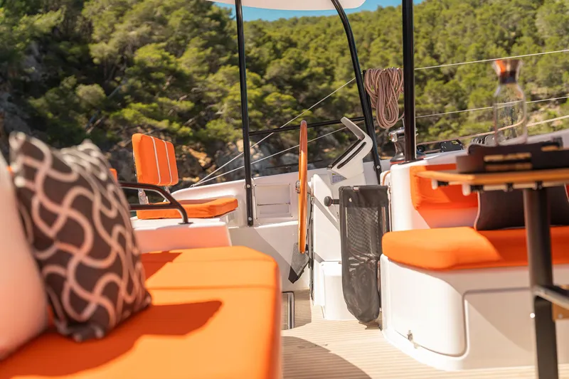  Yacht Photos Pics Luxurious 2026 Excess 13 yacht interior with vibrant orange seating and scenic forest backdrop.
