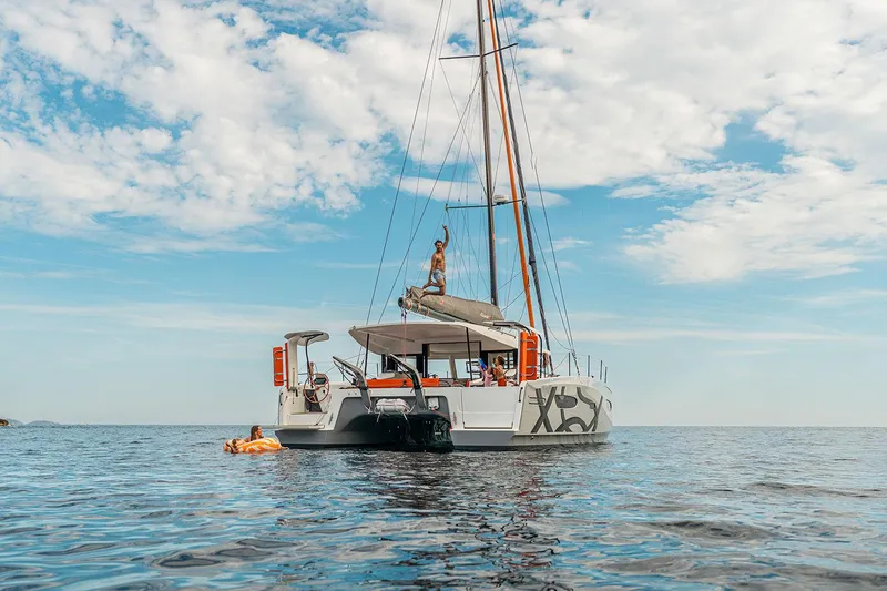  Yacht Photos Pics Sailing catamaran Excess 13, 2026 model, on calm sea with people enjoying the water.