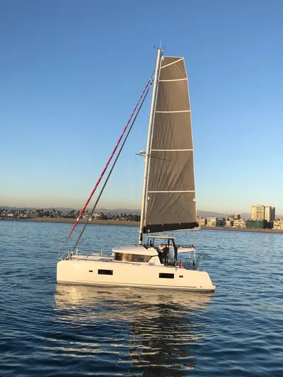 Alegria Yacht Photos Pics 2020 Lagoon 42 catamaran sailing on calm waters at sunset.