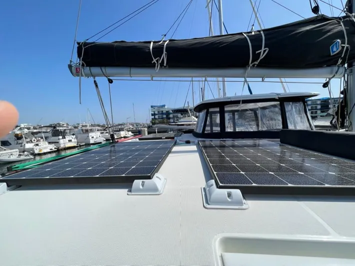 Alegria Yacht Photos Pics 2020 Lagoon 42 catamaran with solar panels docked at a marina under clear blue skies.