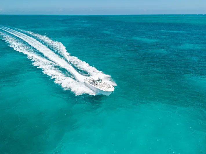  Yacht Photos Pics 2023 Caymas 341 CC boat cruising on clear turquoise ocean waters.