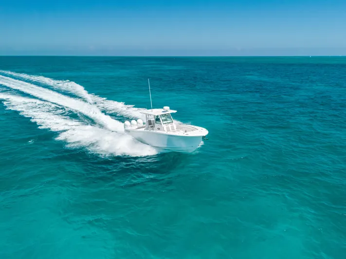  Yacht Photos Pics 2023 Caymas 341 CC boat cruising on clear turquoise ocean waters.