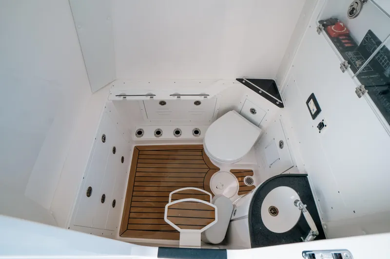  Yacht Photos Pics 2023 Caymas 341 CC boat interior with toilet, sink, and wooden flooring.