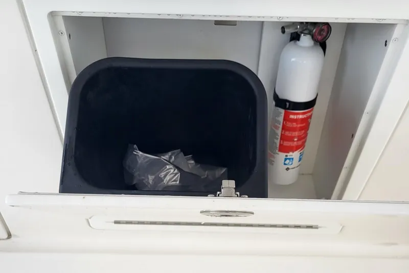  Yacht Photos Pics Storage compartment with trash bin and fire extinguisher on 2023 Caymas 341 CC boat.