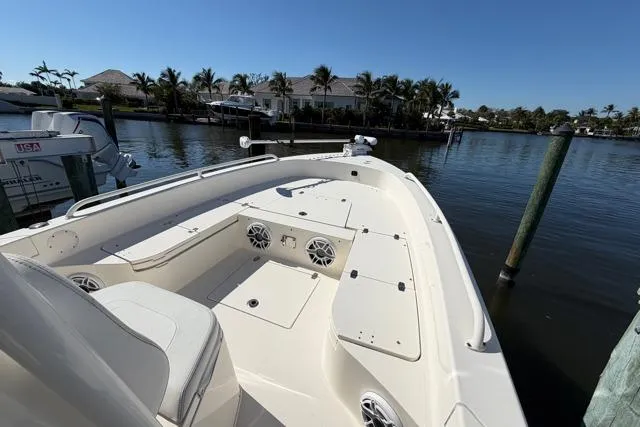  Yacht Photos Pics 2023 Pathfinder 2600 TRS boat docked by waterfront homes under clear blue sky.