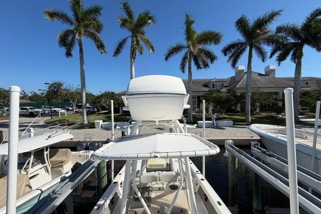  Yacht Photos Pics 2023 Pathfinder 2600 TRS boat docked with palm trees and building in background.