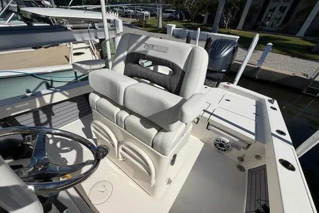  Yacht Photos Pics 2023 Pathfinder 2600 TRS boat interior with cushioned seating and steering wheel.