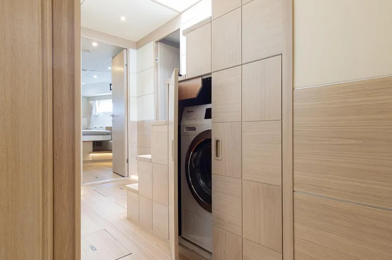  Yacht Photos Pics Laundry area with washer in 2026 Delta Powerboats 72, featuring modern wood paneling.