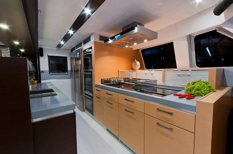 Mulan Yacht Photos Pics Modern kitchen interior on 2012 Sunreef 70 Sailing yacht, featuring sleek cabinetry and stainless steel appliances.