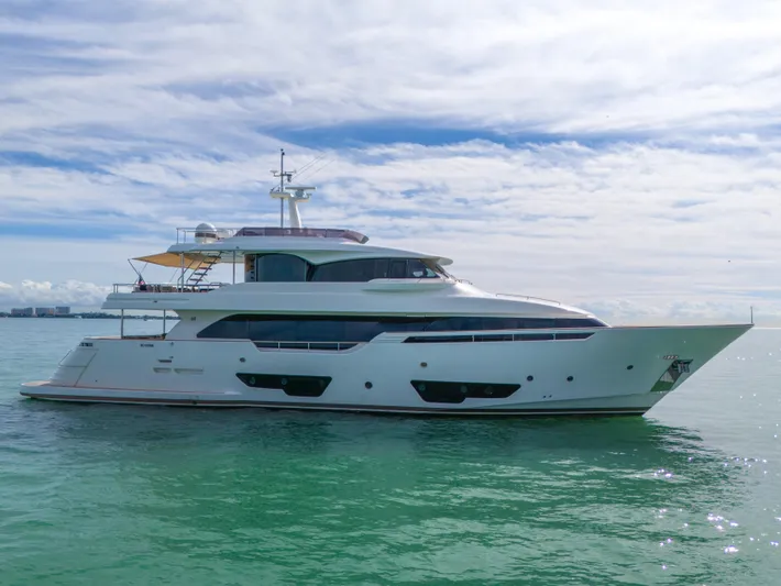 D'vinci Yacht Photos Pics Luxurious 2015 Custom Line Navetta 28 yacht cruising on calm waters under a cloudy sky.