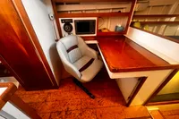 Vintage 1967 custom design interior with wooden desk, chair, and navigation equipment.